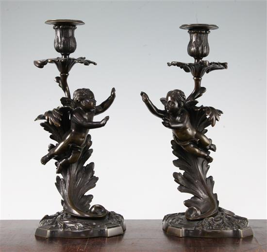 A pair of late 19th century patinated bronze candlesticks, 12ins high